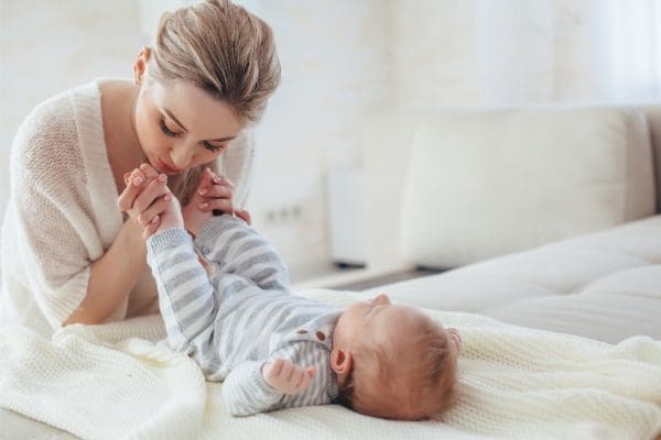 赤ちゃんの足にキスするお母さん